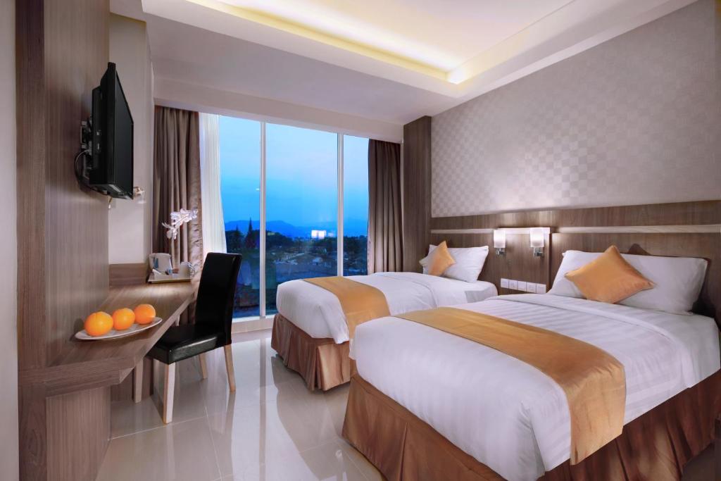 Postel nebo postele na pokoji v ubytování Aston Lampung City Hotel