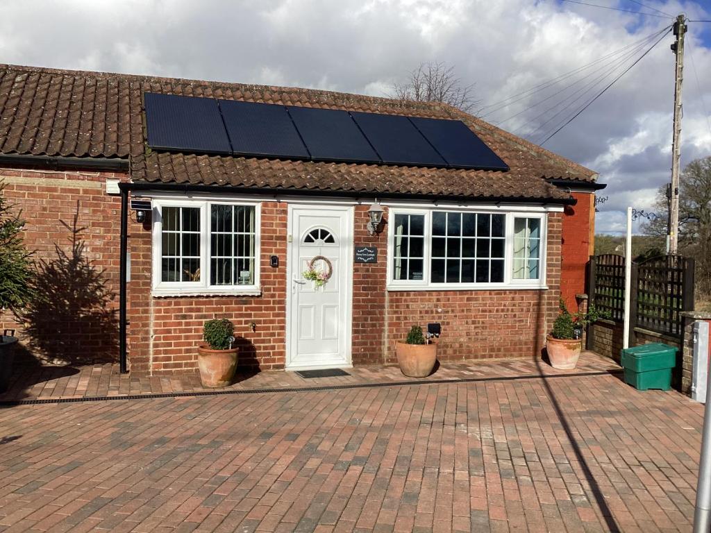 uma casa com painéis solares na porta da frente em New Inn Lodge In Scarning Near Dereham Norfolk em East Dereham