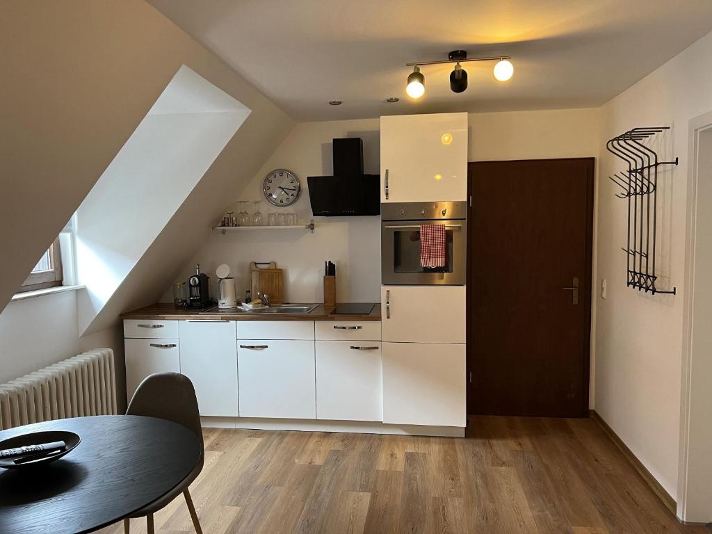 a small kitchen with white cabinets and a table at Ferienwohnung 8 Torster - im Zentrum der Altstadt in Hameln