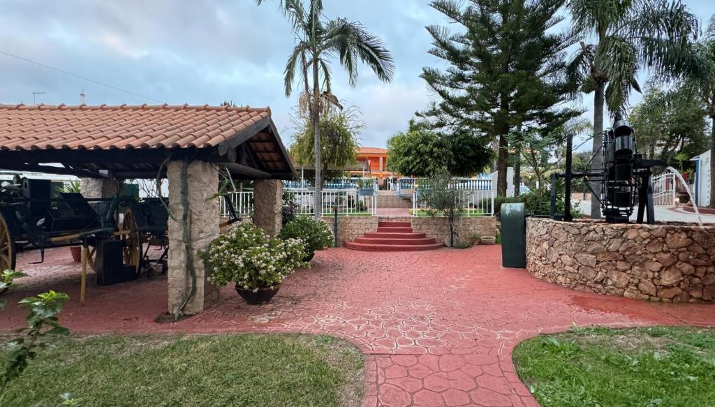 een stenen loopbrug met een paviljoen en palmbomen bij Quinta Jardim das Palmeiras, T2 n 8 , Algoz in Silves