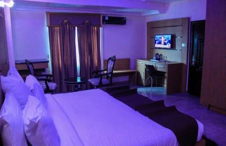 Habitación de hotel con cama grande y escritorio. en Desikok Royal Hotel LTD, en Port Harcourt