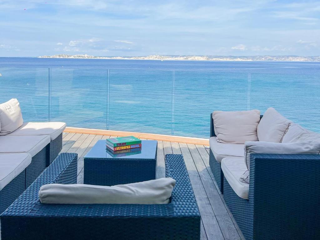 a balcony with chairs and a view of the ocean at Villa luxe vue mer panoramique - sauna-hamam - jacuzzi in Marseille
