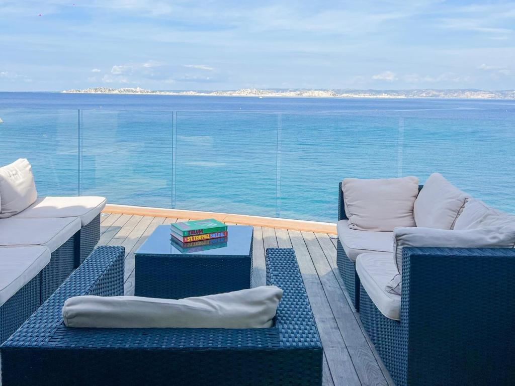 Un balcón con sillas y vista al mar. en Villa vue mer panoramique - sauna - balnéothérapie, en Marsella