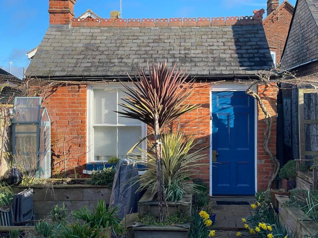 une maison en briques rouges avec une porte bleue dans l'établissement Little House Felixstowe, à Felixstowe