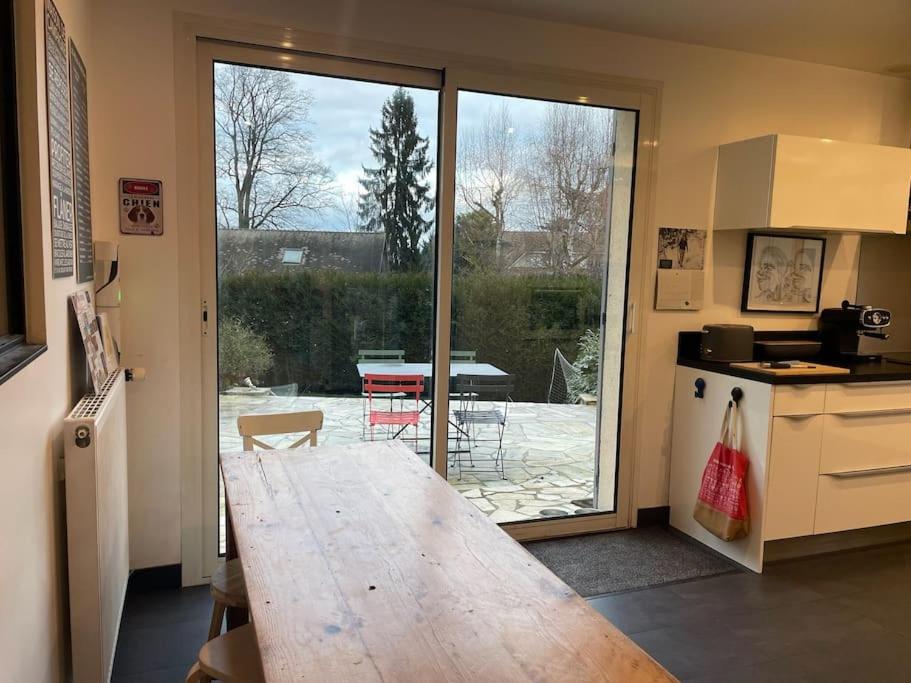 une cuisine avec une table en bois en face d&#39;une terrasse dans l&#39;établissement Grande maison familiale -12 pers, à Méré