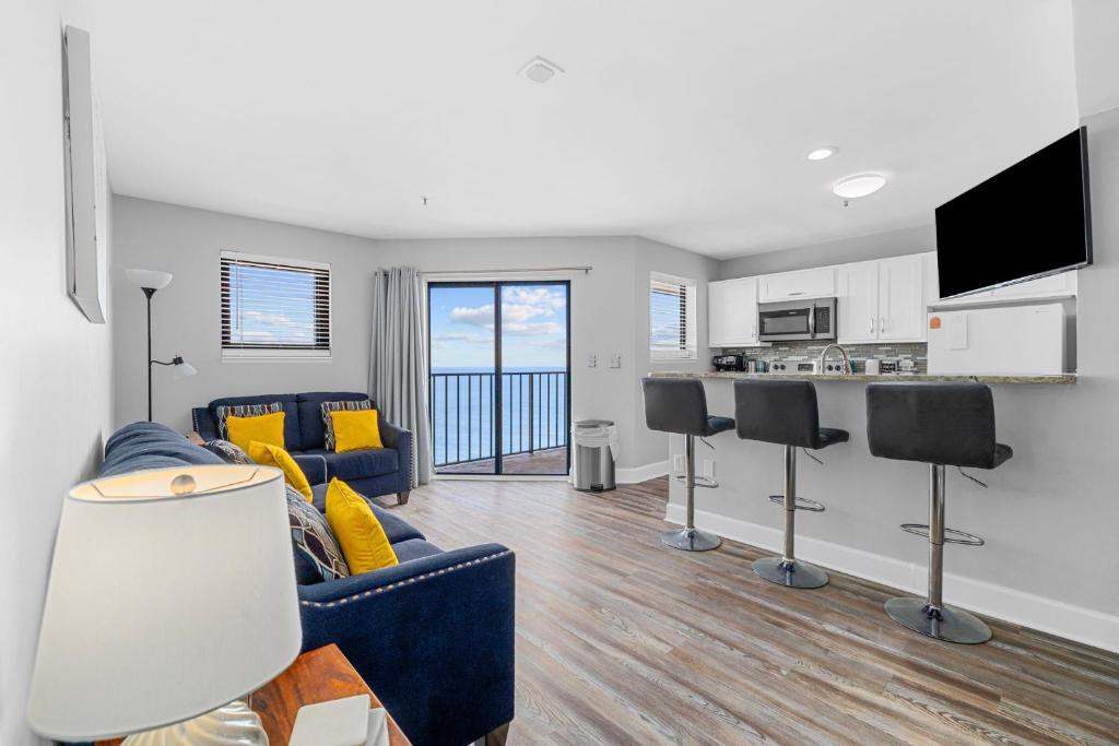sala de estar con sofá azul y cocina en Beautiful 2BR Penthouse with Amazing Views, en Myrtle Beach