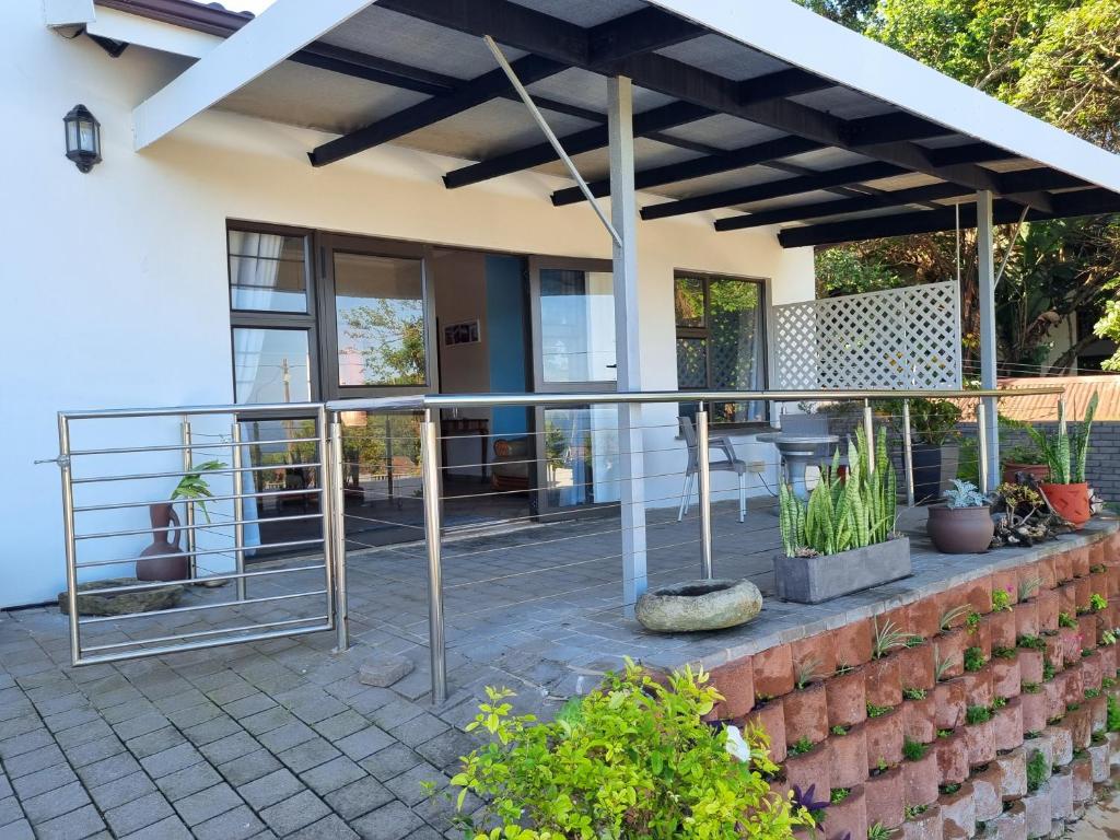 a patio of a house with a metal railing at Spacious apartment with lovely sea view in Hibberdene