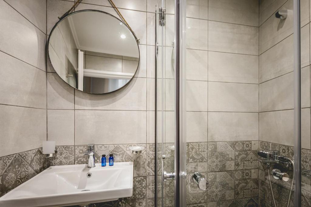 a bathroom with a shower and a sink and a mirror at pension Acronafplia ( building C ) in Nafplio