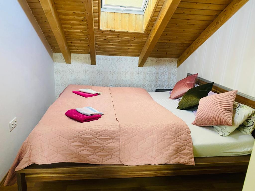 Schlafzimmer mit einem Bett mit rosa Bettwäsche und Kissen in der Unterkunft Design apartment in Bratislava