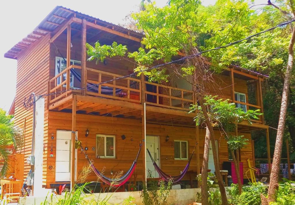 a wooden house with a balcony on the side of it at TOnat Caribe Hostel in West End