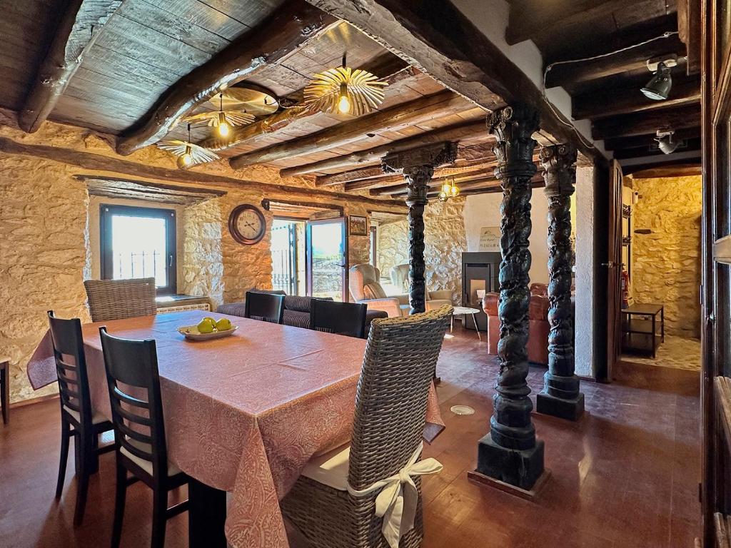 un comedor con una gran mesa de madera y sillas en Casa Rural Muralla de Haza, en Haza