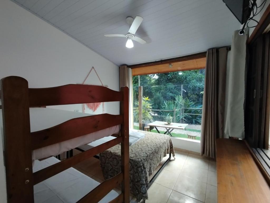 a bedroom with a bunk bed and a large window at Toca do Roka in Socorro