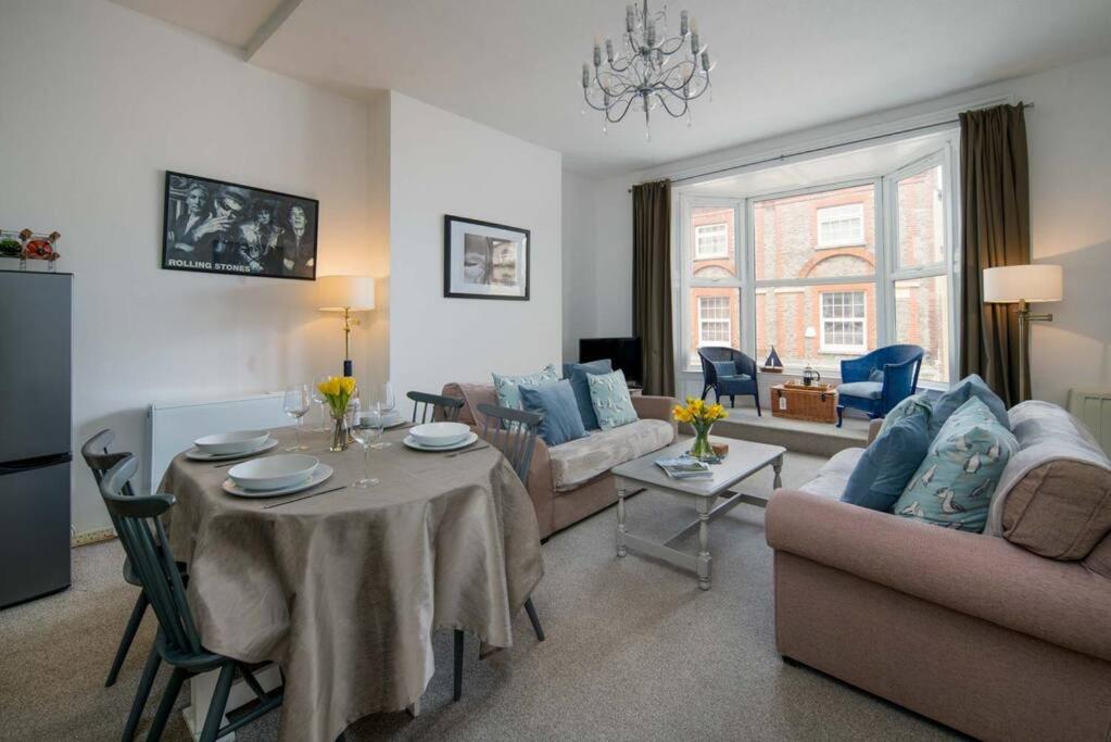 un soggiorno con divano, tavolo e sedie di The Seagull Apartment a Cowes