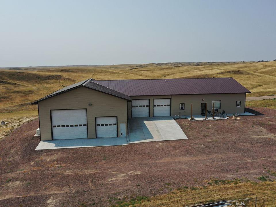 a building with four garage doors in a field at MJSmith Rentals in Ogallala