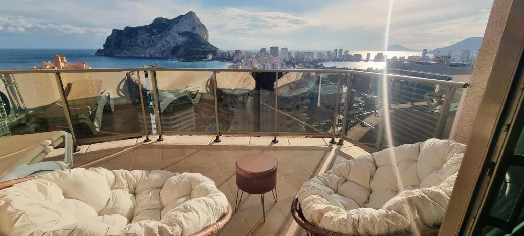 Un balcón con una silla blanca y vistas al océano. en Esmeralda Suites Sunrise, en Calpe