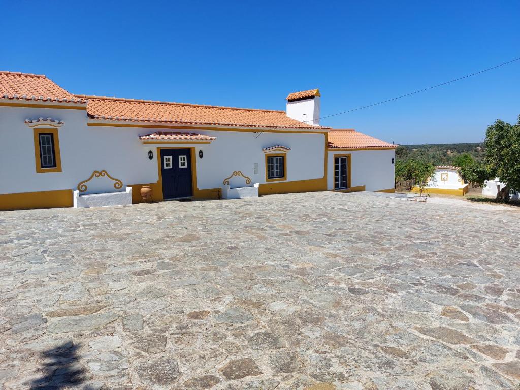 a house with a stone driveway in front of it at Monte Santiago in Fronteira