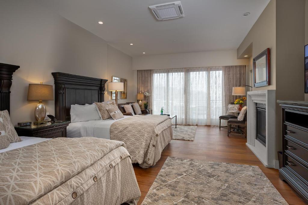 a hotel room with two beds and a television at Rockport Harbor Hotel in Rockport