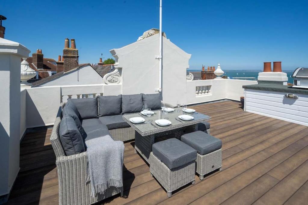 a patio with a couch and a table on a roof at Theatre House Fantastic 3bed apartment Sea views. in Cowes