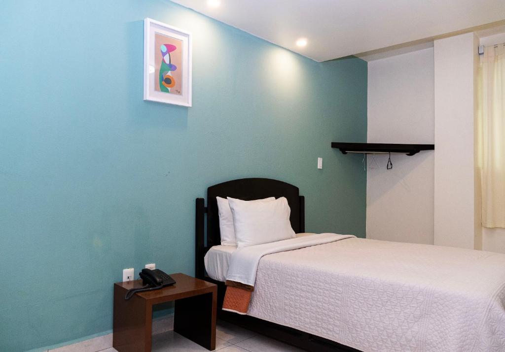 1 dormitorio con 1 cama y 1 mesa con teléfono en HOTEL KRISTAL, en Asunción Nochixtlán