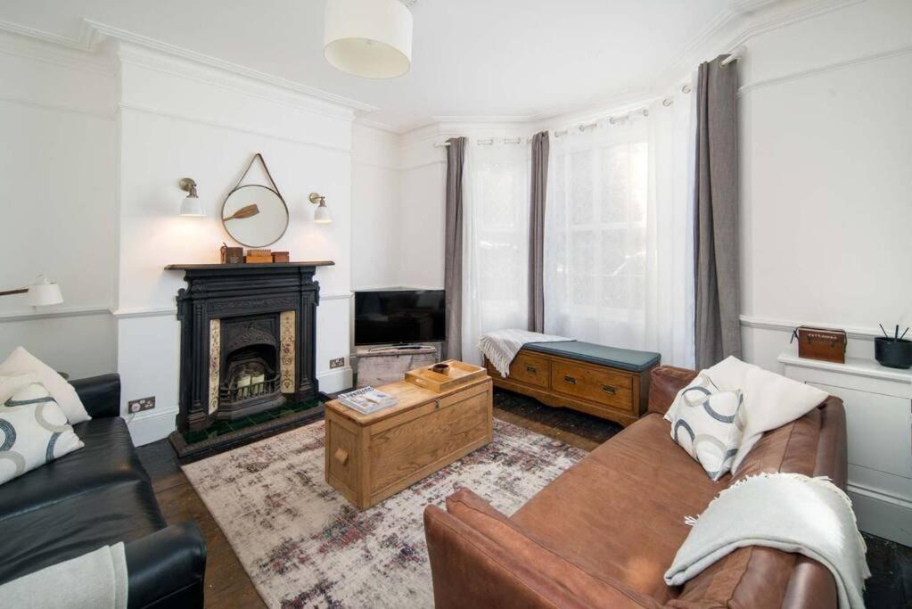 ein Wohnzimmer mit einem Sofa und einem Kamin in der Unterkunft Westhill, Cowes Town House in Cowes