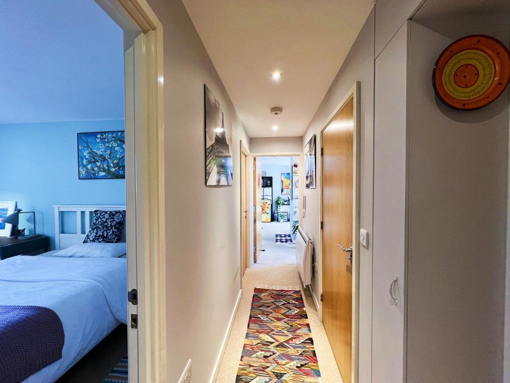 un couloir menant à une chambre avec un lit et un tapis dans l'établissement A private bedroom with art style located in the city center, à Portsmouth
