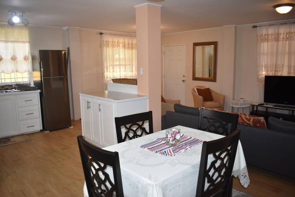 a kitchen and living room with a table and a couch at Belle Zoon Villa in Cap Estate