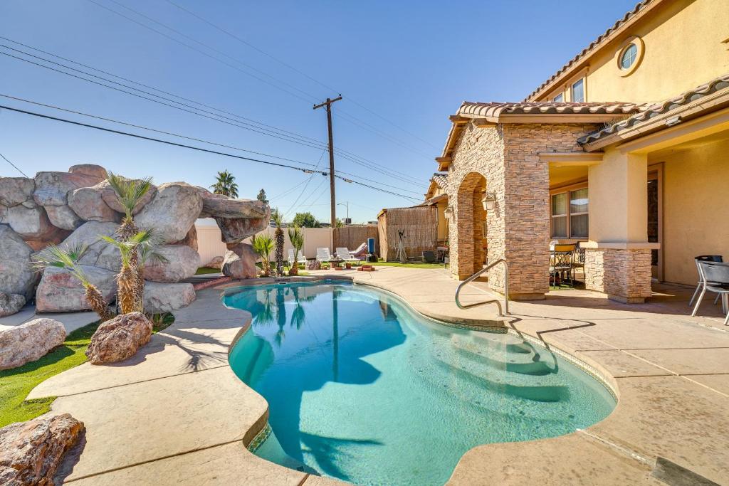 a swimming pool in a yard next to a house at North Las Vegas Home about 9 Mi to the Strip! in Las Vegas