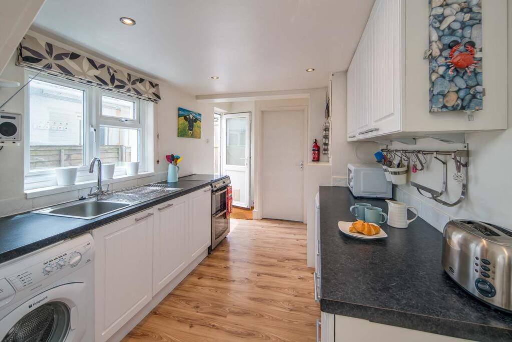 a kitchen with a sink and a dishwasher at Windward cottage, a great 3bed house in Cowes in Cowes