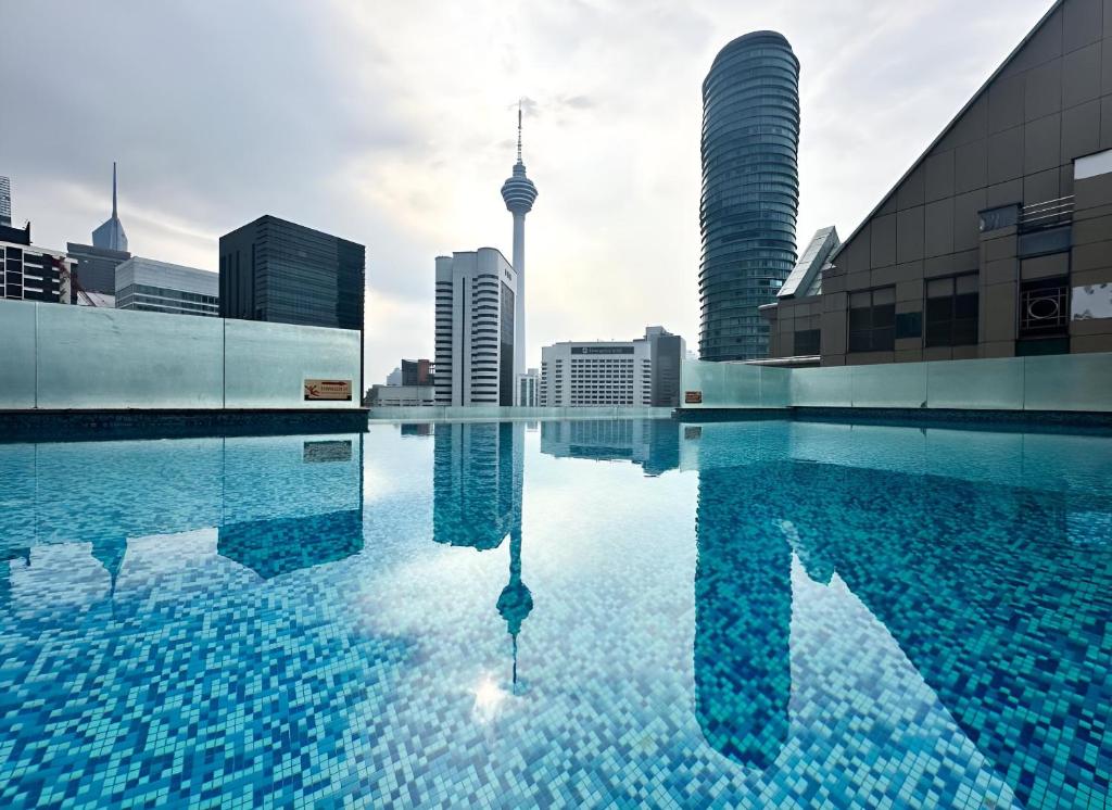 a swimming pool in a city with tall buildings at KLCC Cormar Premium Suites at Kuala Lumpur City Center in Kuala Lumpur