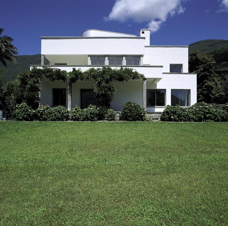 a white house with a large lawn in front of it at Casa Navegna in Minusio