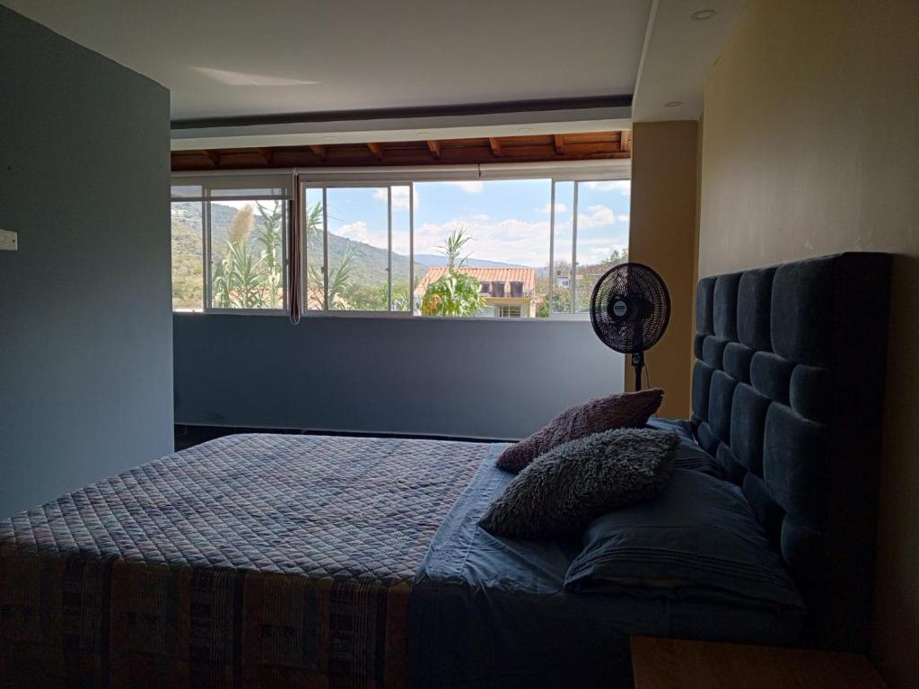 - une chambre avec un lit et une grande fenêtre dans l'établissement Apartamento Torres del Castillo, à San Gil