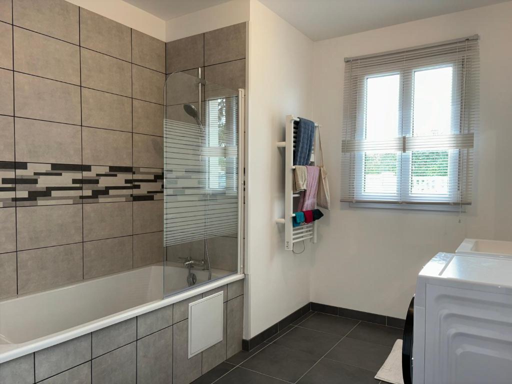 a bathroom with a bath tub and a sink at Les clés de jonzac-conciergerie la maison des 4 Saisons in Ozillac
