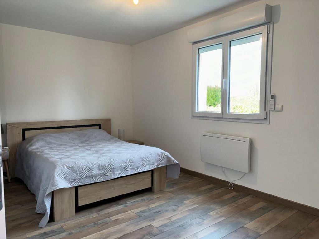 a bedroom with a bed and a window at Les clés de jonzac-conciergerie la maison des 4 Saisons in Ozillac