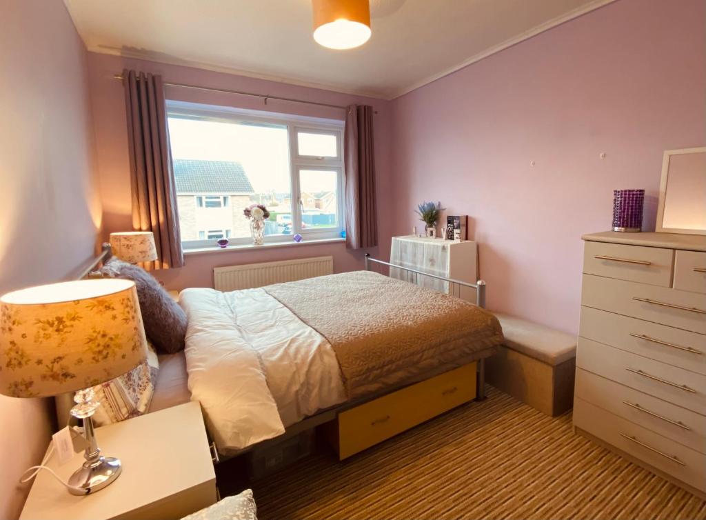 a bedroom with a bed and a window at Purple dream double bedroom in Cheltenham