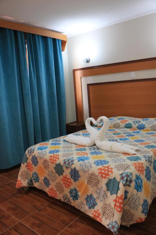 Un dormitorio con una cama con cisnes. en Hotel Garden Latorre en Iquique