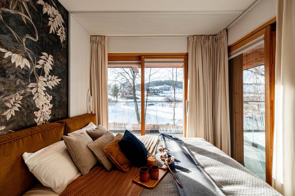 a bedroom with a bed with a large window at TatryGold - Białka SPA & Resort - Apartament Potoku Szum in Białka Tatrzanska