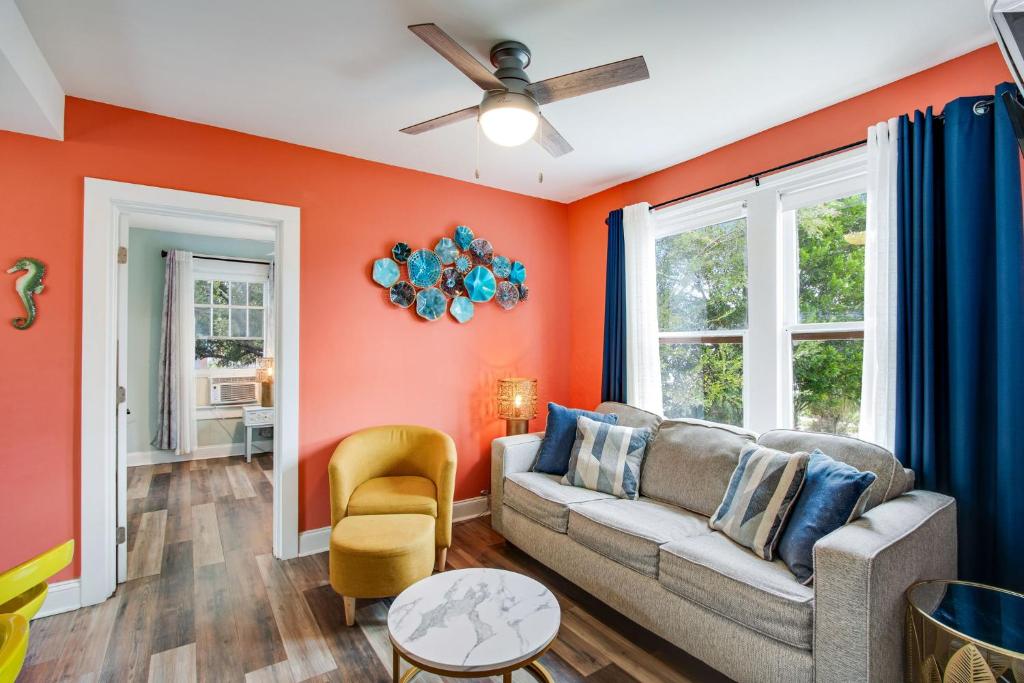 a living room with orange walls and a couch at Downtown Navy Blue in Pensacola