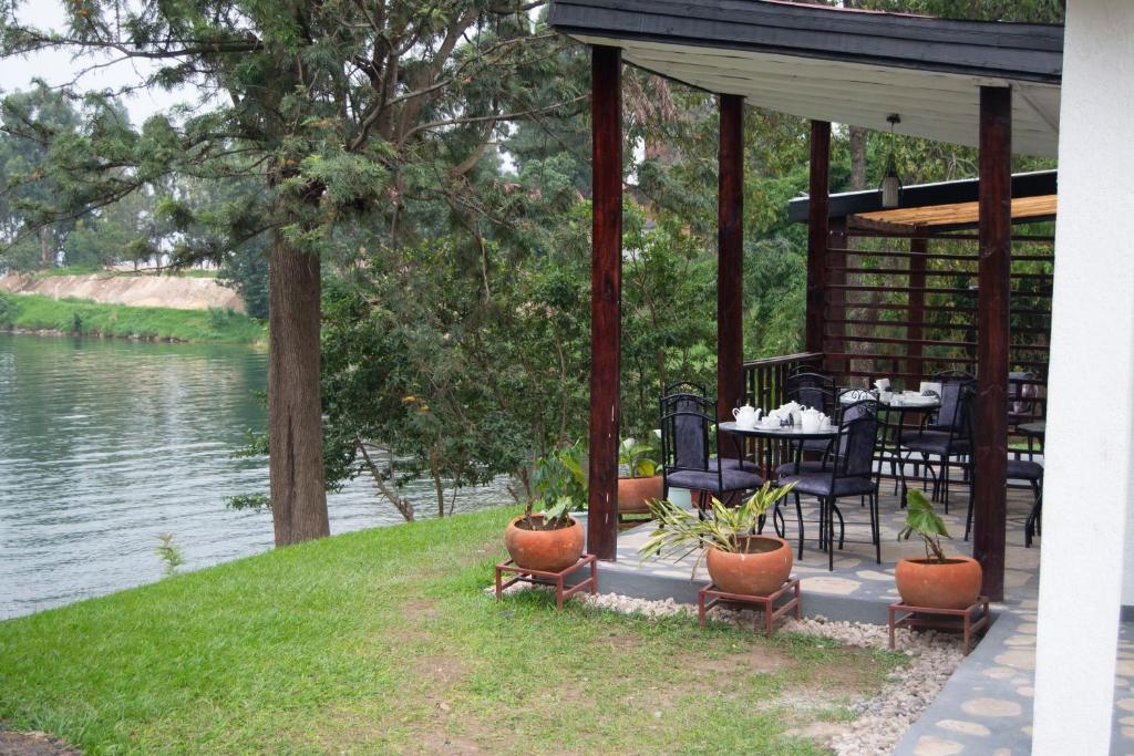 cenador con mesa y sillas junto a un lago en La Casa Nostra Rubavu en Rubavu