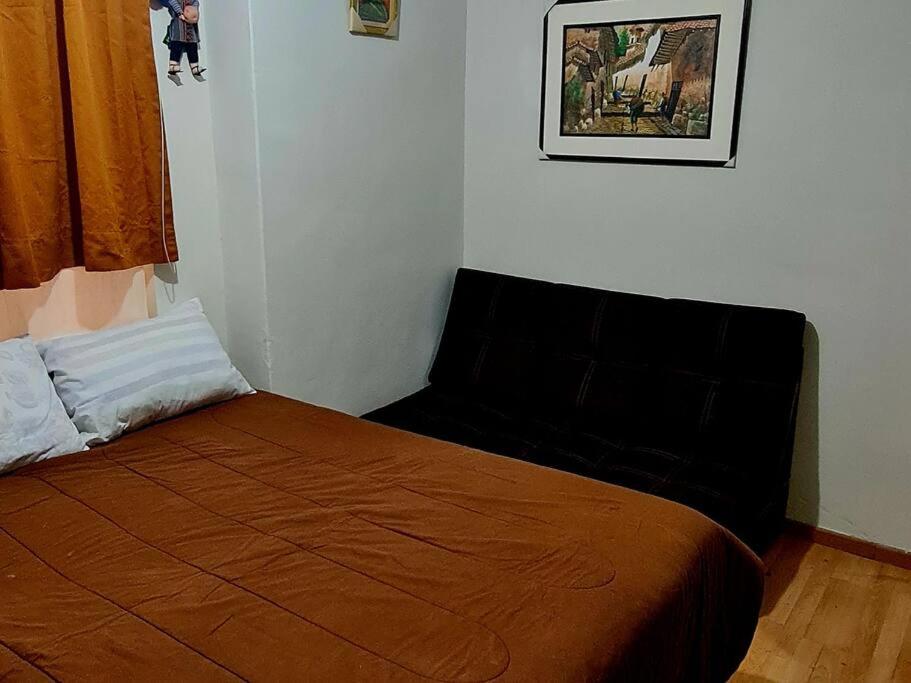 een slaapkamer met een bed met een oranje deken bij Atahuallpa ukumary in Cuzco