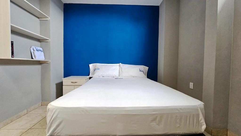 a bed in a room with a blue wall at Sensity Home Recamara moderna in Tehuacán