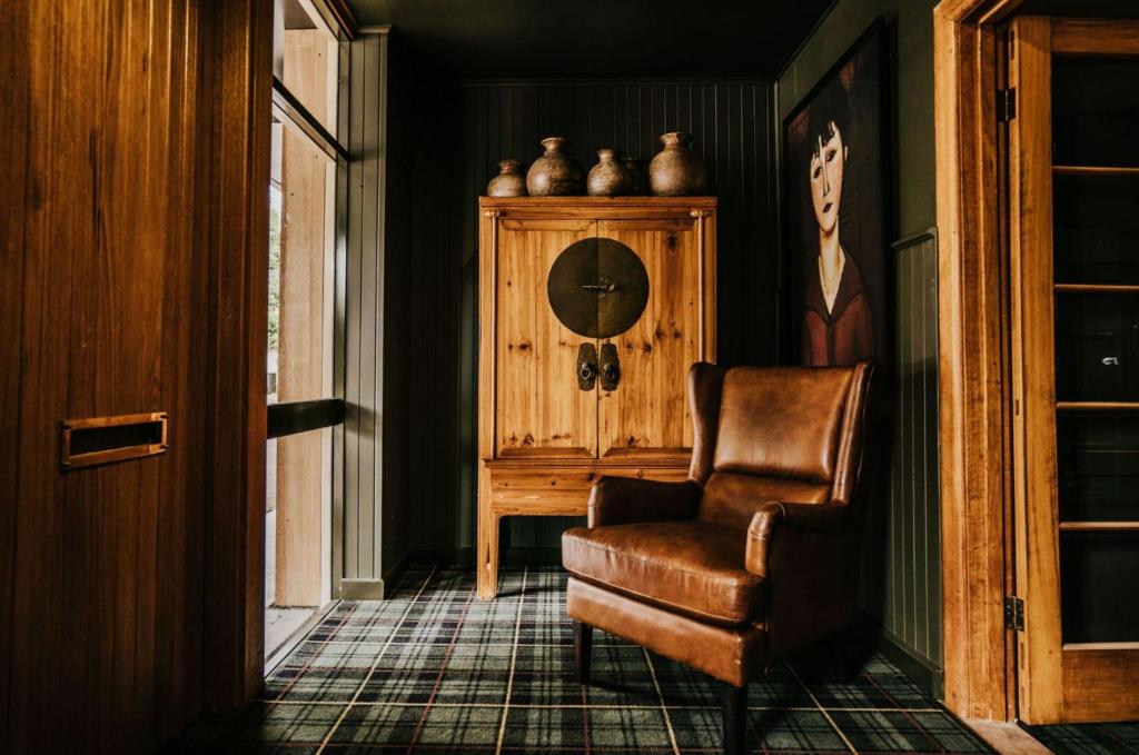 uma sala de estar com uma cadeira e um armário em The Amalfi Minimalist Room 607 em Hepburn Springs