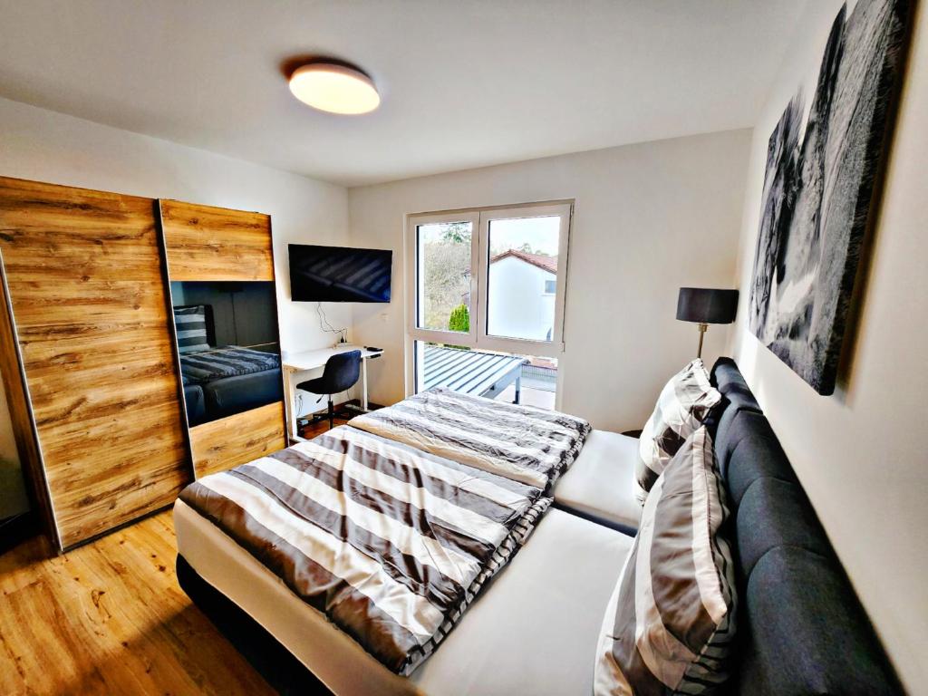1 dormitorio con cama y ventana en Lions Place Premium Apartments BUSINESS optionaler Zugang zum SPA- Bereich, en Heidenheim an der Brenz