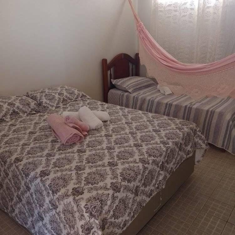 een slaapkamer met twee bedden met roze kussens erop bij Pousada Rainha do Mar in Beberibe