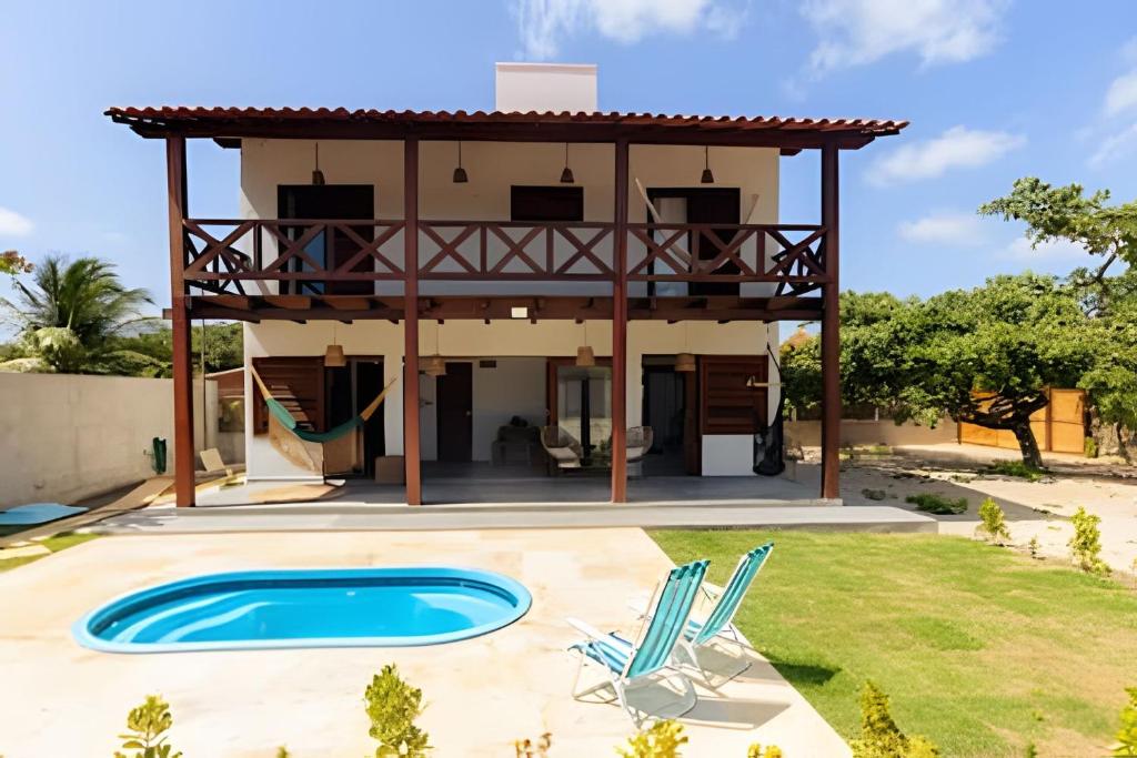 a villa with a swimming pool and a house at Casa com piscina na tranquilidade de Barra Grande in Barra Grande