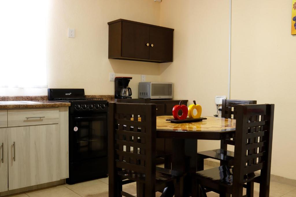 una cucina con tavolo, sedie e piano cottura di Sensity Home Apartamento hermoso y centrico a Tehuacán