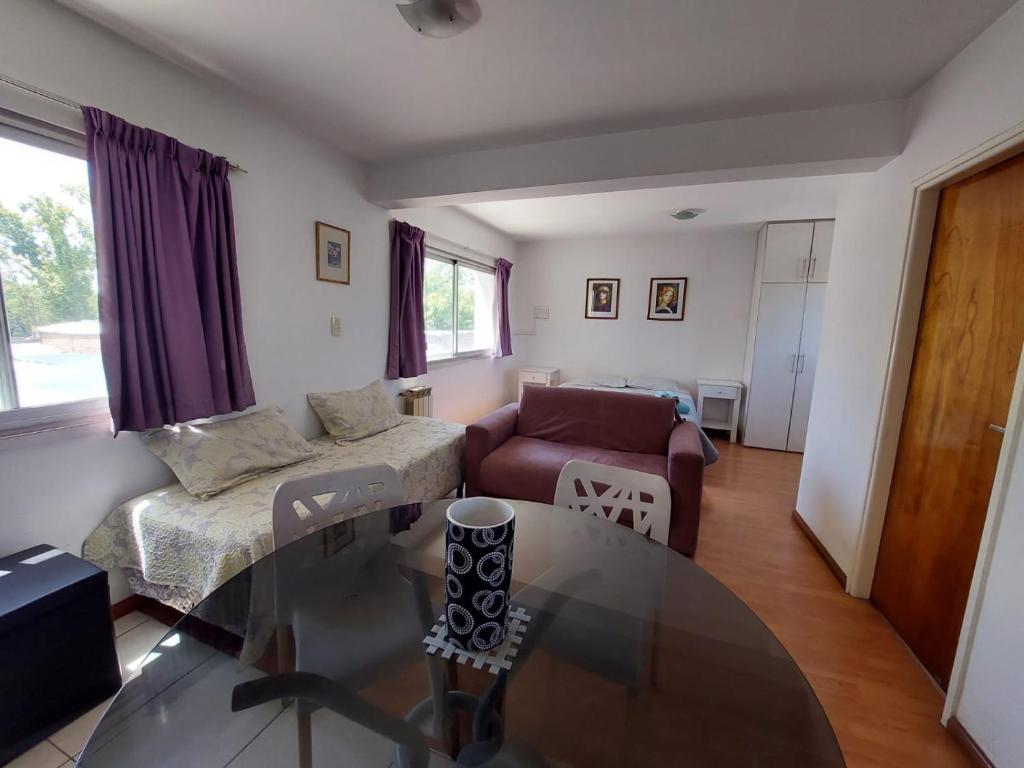 a living room with a couch and a glass table at Cozy I monoambiente en ciudad de Mendoza in Mendoza