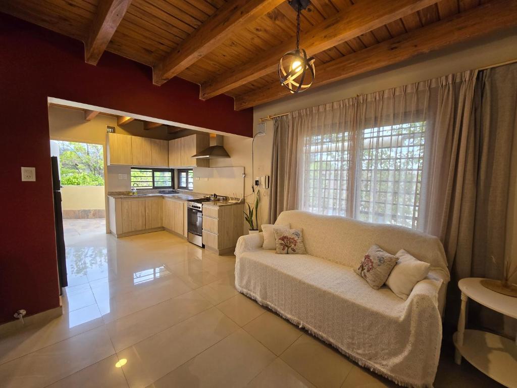 een woonkamer met een witte bank en een keuken bij La Velez in Guaymallen