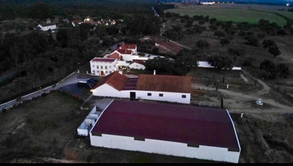 eine Luftansicht eines großen weißen Gebäudes mit rotem Dach in der Unterkunft Herdade de Santa Maria in Almeirim