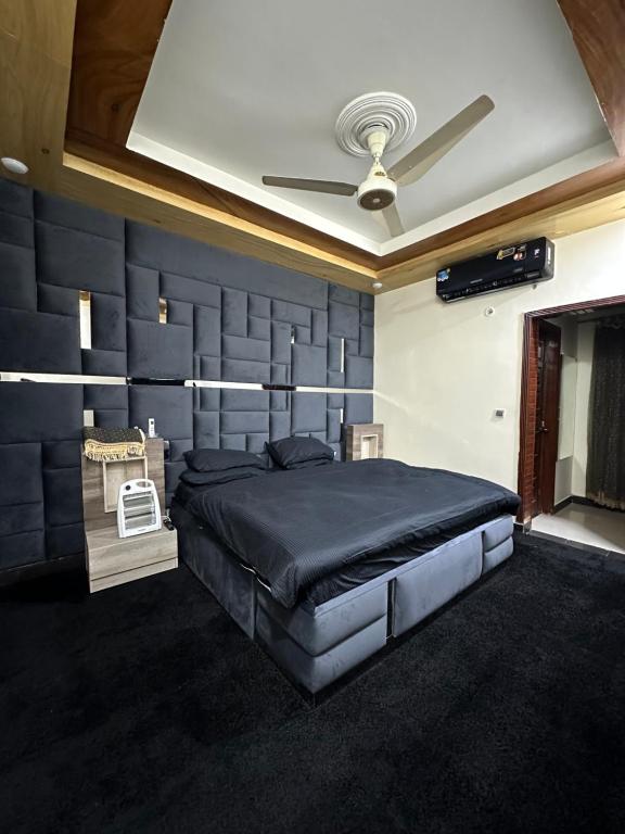 a bedroom with a large bed with a blue wall at HHH Brothers House in Rawalpindi