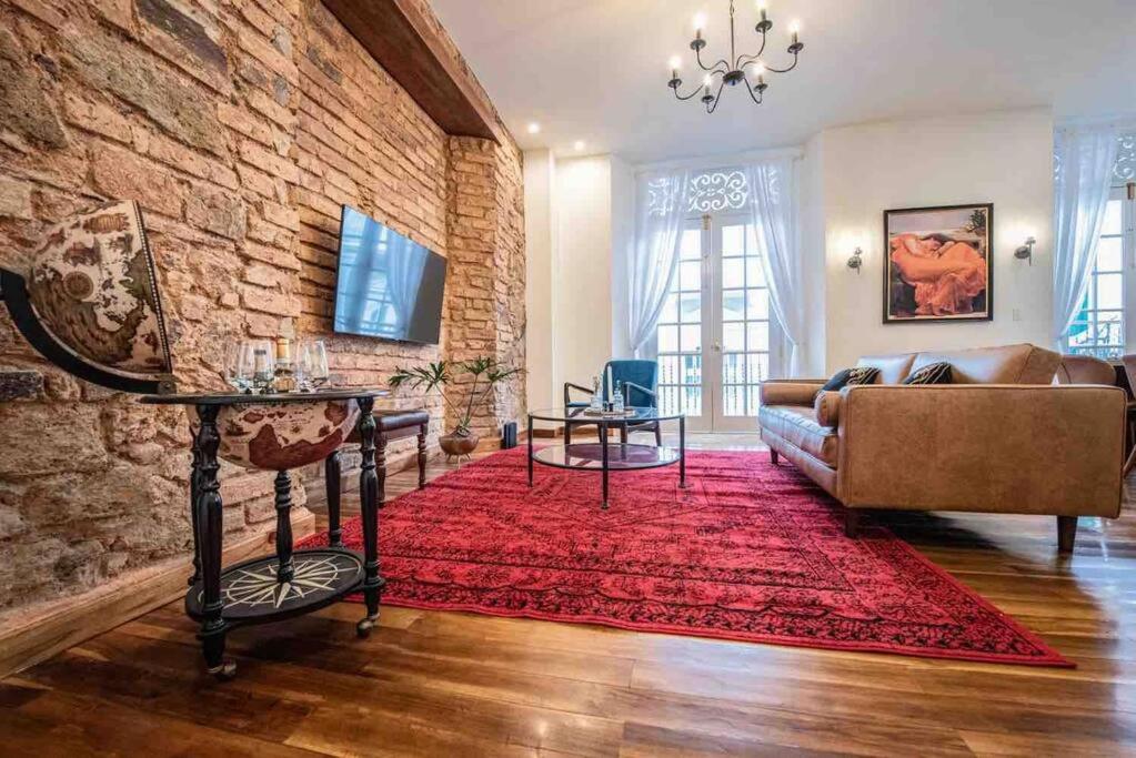 uma sala de estar com um sofá e um tapete vermelho em LUXURY Mid-Century Apartment In Casco Viejo na Cidade do Panamá